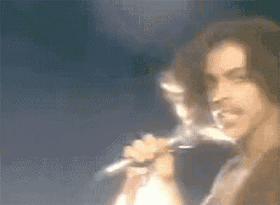 a blurry picture of a man singing into a microphone on a stage .