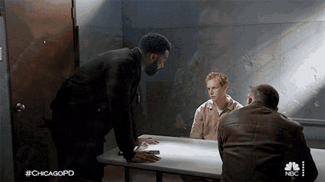 three men are sitting at a table in a room with #chicagopd on the bottom right