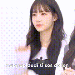 a woman with long black hair is standing next to another woman and the words naky applaudi si sos de len are above her .