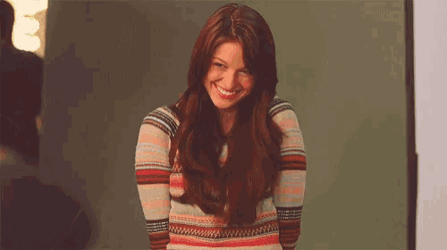 a woman in a striped sweater is smiling