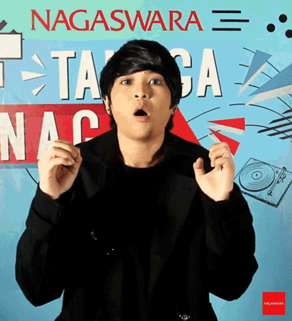 a young man is standing in front of a sign that says nagaswara