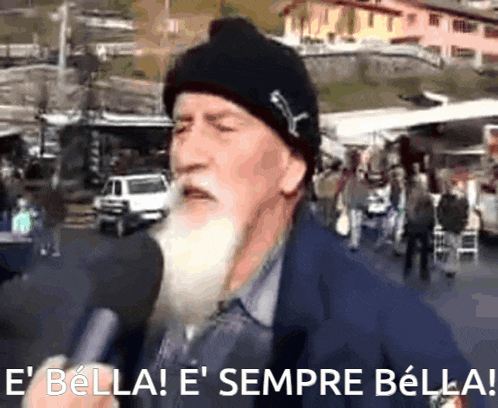 a man with a beard is talking into a microphone with the words e bella e sempre bella