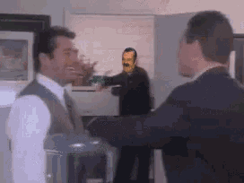 a man in a suit is talking to another man in a suit