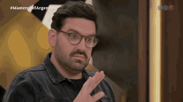 a man with glasses and a beard is on a tv show called master chef argentina
