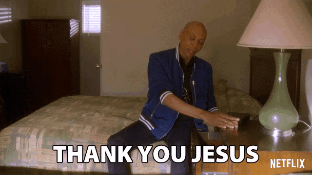 a man sits on a bed next to a table that says thank you jesus on it