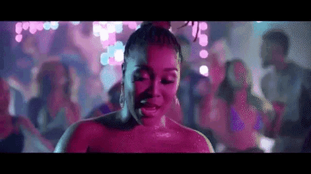 a woman is standing in front of a crowd of people at a party .