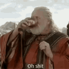 a man with a beard is drinking from a glass while wearing a robe .