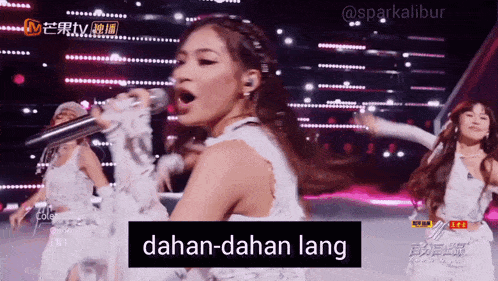 a woman singing into a microphone with the word dahan-dahan lang written on the bottom