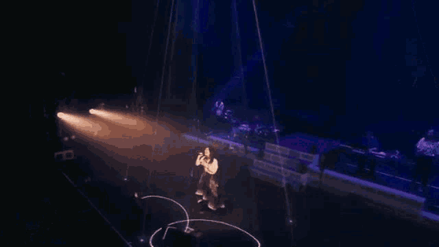 a woman is singing into a microphone on stage .