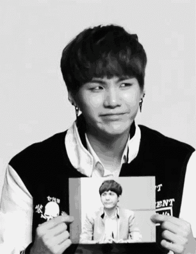 a black and white photo of a young man with a jacket that says ent