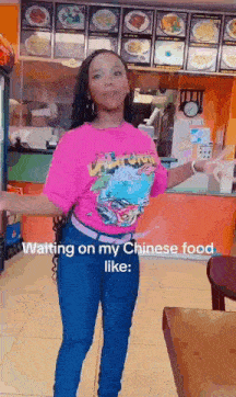 a woman in a pink shirt is standing in front of a chinese food counter