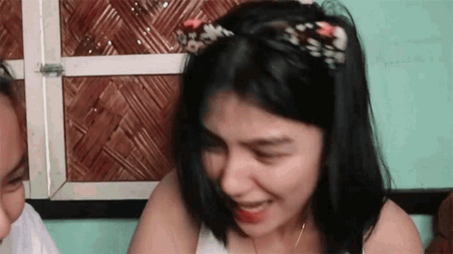 a woman wearing a cat ear headband is sitting next to a man and smiling .