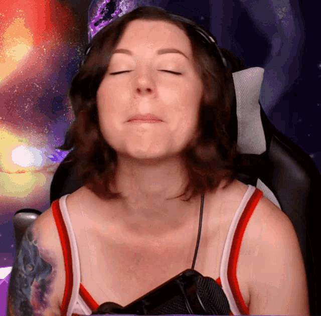 a woman with her eyes closed and a tattoo on her arm