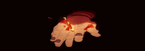 a close up of a person 's hand holding a fireball in a dark room .