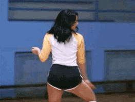 a woman in shorts and socks is dancing on a court