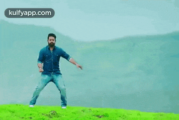 a man is jumping in the air in front of a tree with kulfyapp.com written in the corner