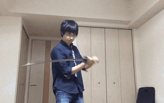 a young man is holding a sword in a room