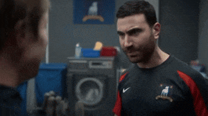 a man wearing a bantr jersey is crying while talking to another man