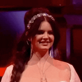 a close up of a woman wearing a tiara and ear buds .