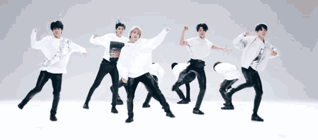 a group of young men are dancing together in a white room .