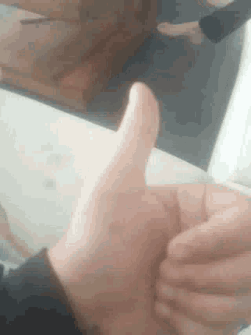 a close up of a person giving a thumbs up sign