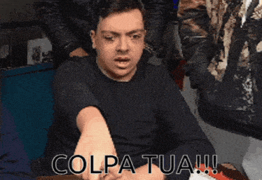 a man in a black shirt with the words colpa tua