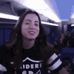 a woman wearing a raiders shirt is sitting on a plane .