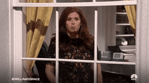 a woman is looking out of a window with her mouth open .