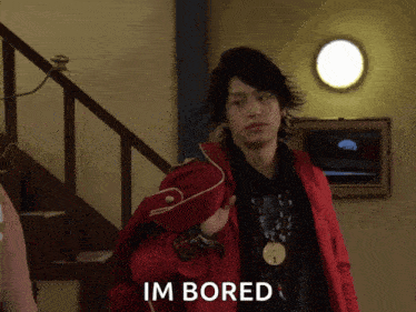 a man in a red jacket says im bored in front of stairs