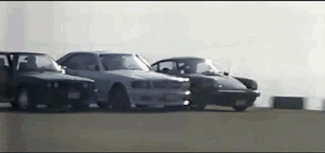 a row of cars are parked on a road .