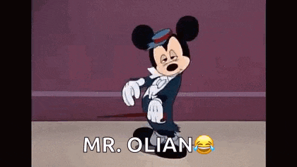 mickey mouse is wearing a tuxedo and pointing at the camera with the words `` mr. olian '' .