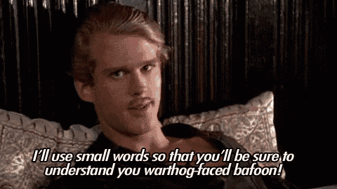 a man with a beard is sitting on a bed with a pillow and a quote from a movie .