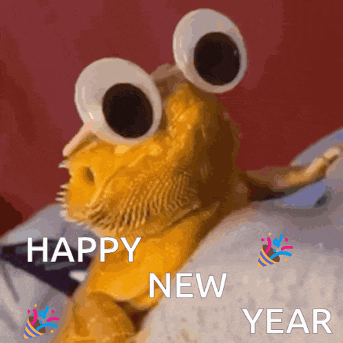 a bearded dragon with googly eyes is laying on a bed and says happy new year