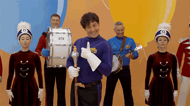 a man in a purple outfit is holding a drum that says yamaha