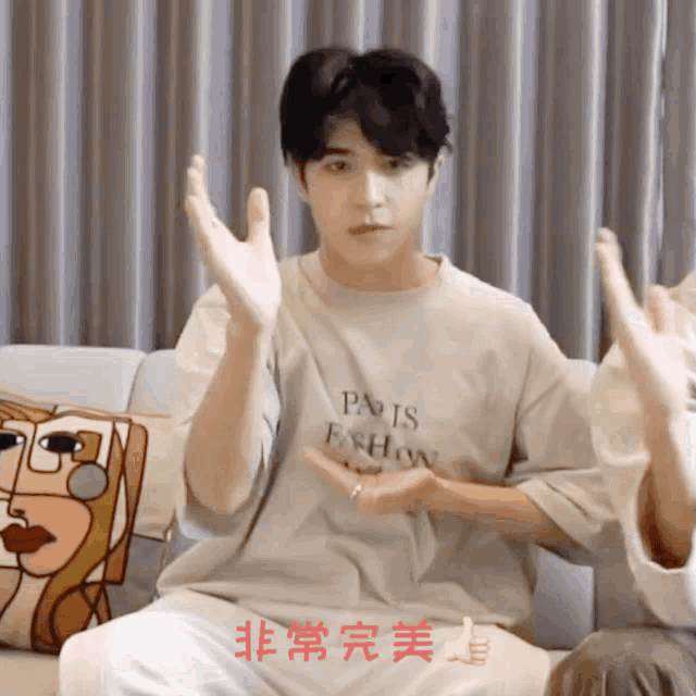 a man wearing a paris fashion t-shirt is clapping