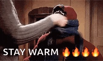 a person is putting a scarf around another person 's neck with the words `` stay warm '' written above them .