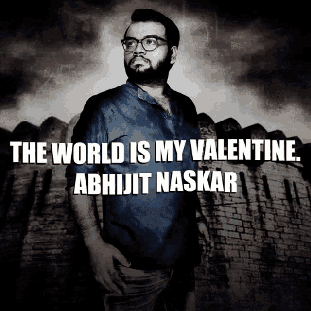 a man with glasses stands in front of a brick wall with the words " the world is my valentine " above him