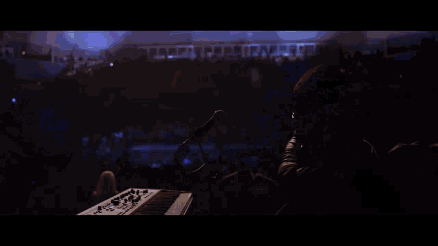 a man is singing into a microphone with a blue background