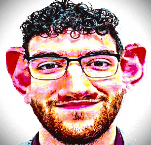 a man with curly hair wearing glasses and a beard looks at the camera