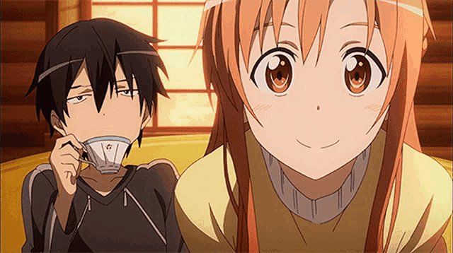 a boy drinking from a cup next to a girl who is smiling