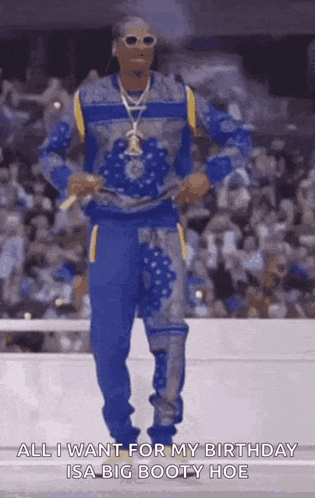 snoop dogg is dancing in front of a crowd and says all i want for my birthday is a big booty hoe .