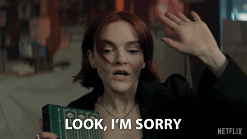 a woman holding a book and saying look i 'm sorry
