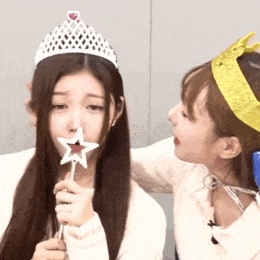 a girl wearing a tiara is holding a star in her hand