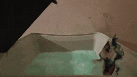 a woman is taking a bath in a bathtub filled with green water