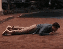 a man is laying on his stomach on a brick pavement .