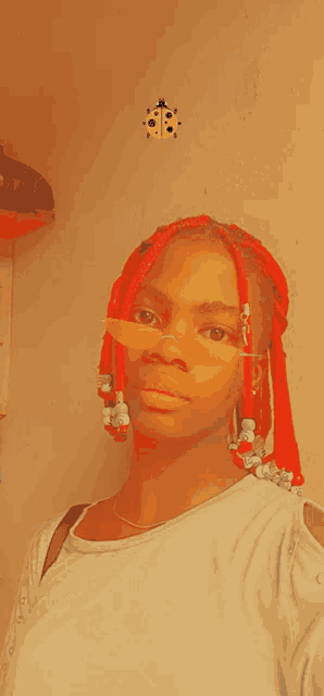 a girl with red braids is wearing sunglasses and a ladybug on her face