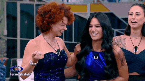 three women are standing next to each other with the hashtag grandefratello on the bottom right