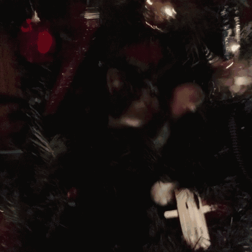a close up of a christmas tree with decorations and a cat 's paws