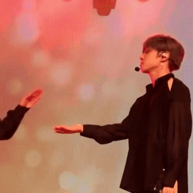 a man and a woman are standing next to each other on a stage and shaking hands .