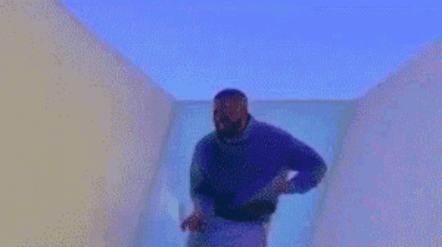 a blurry picture of a man standing in a room with a purple light behind him .